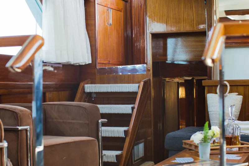 New School Yacht Photos Pics Interior of 1966 Chris-Craft Constellation yacht with wooden paneling and cozy seating area.