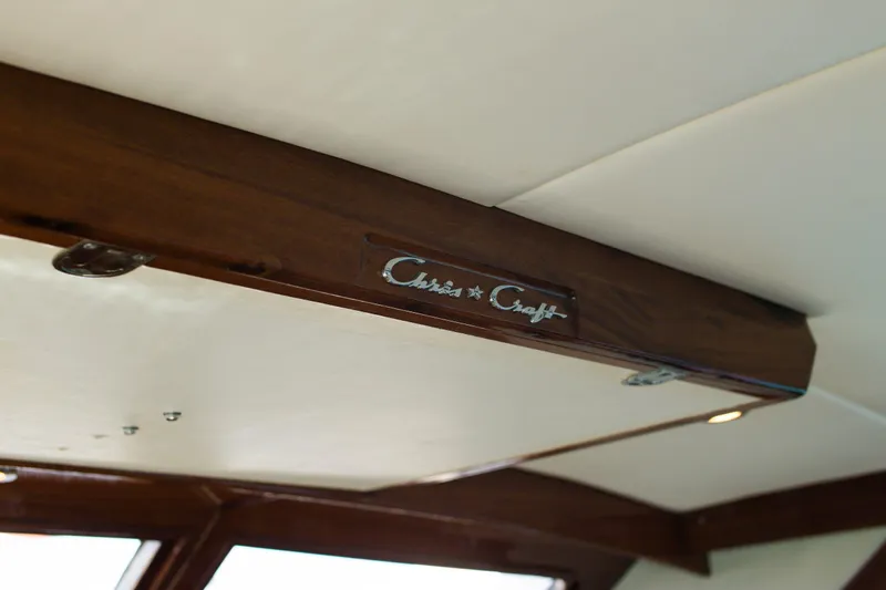 New School Yacht Photos Pics Interior view of 1966 Chris-Craft Constellation with wooden beam and logo.