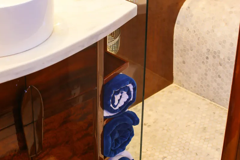 New School Yacht Photos Pics Luxurious 1966 Chris-Craft Constellation bathroom with elegant wood cabinetry and plush blue towels.