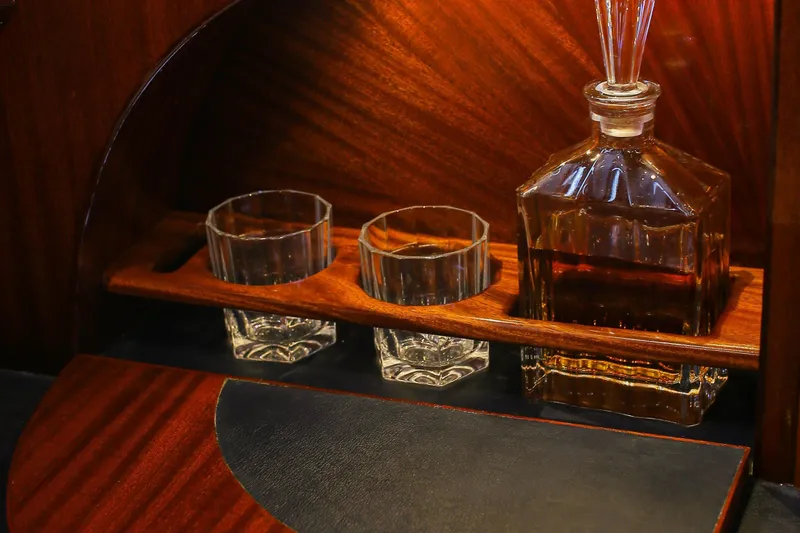 New School Yacht Photos Pics Luxurious wooden bar setup on 1966 Chris-Craft Constellation yacht with decanter and glasses.