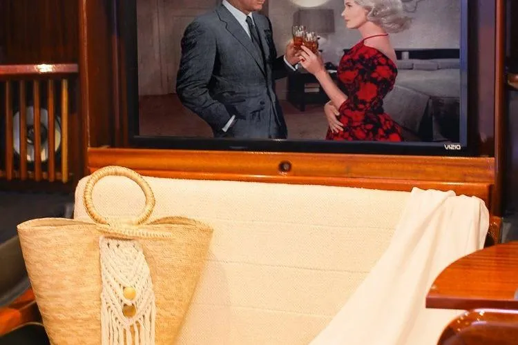 New School Yacht Photos Pics 1966 Chris-Craft Constellation interior with a TV, straw bag, and elegant decor.