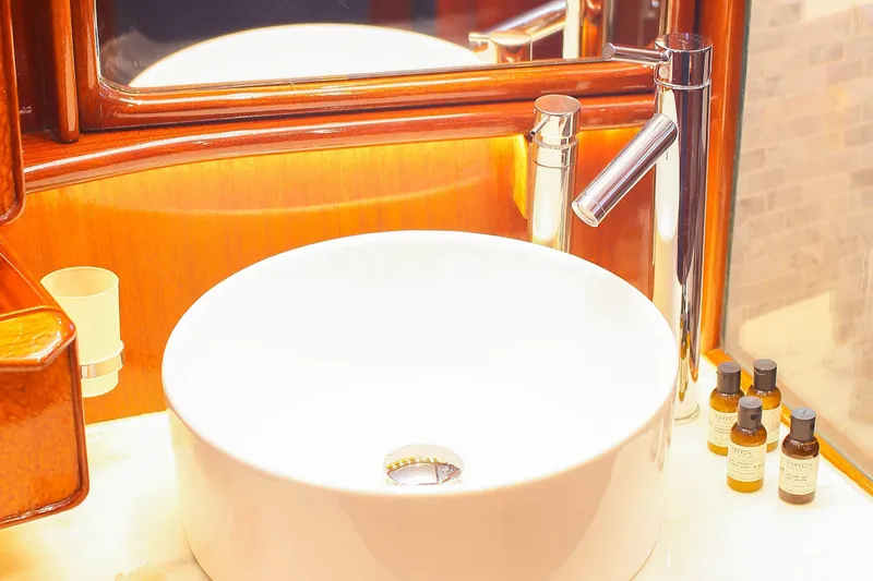 New School Yacht Photos Pics Luxurious bathroom sink on 1966 Chris-Craft Constellation yacht with elegant fixtures and toiletries.