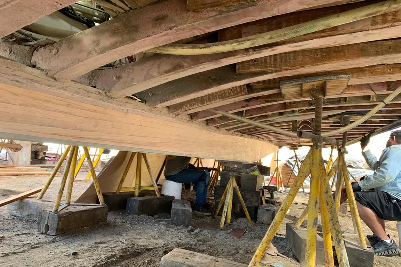 New School Yacht Photos Pics 1966 Chris-Craft Constellation under restoration, showcasing wooden hull and support structures.