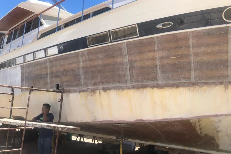 New School Yacht Photos Pics 1966 Chris-Craft Constellation yacht under maintenance, with visible hull restoration work.