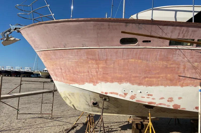 New School Yacht Photos Pics 1966 Chris-Craft Constellation boat under restoration, showing sanded hull and scaffolding.