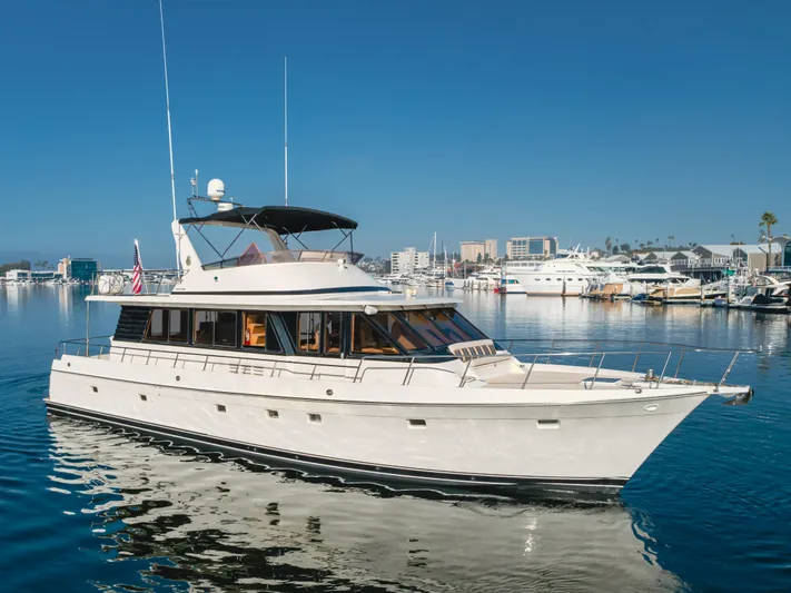 Artemis Yacht Photos Pics 1996 Offshore Yachts Pilothouse cruising in a marina under clear blue skies.