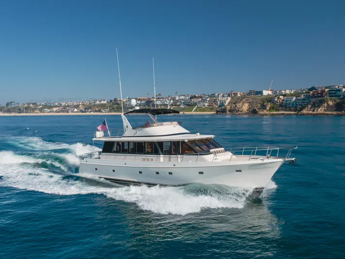 Artemis Yacht Photos Pics 1996 Offshore Yachts Pilothouse cruising on blue ocean near coastline.