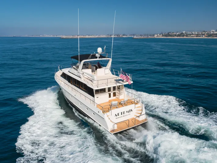 Artemis Yacht Photos Pics 1996 Offshore Yachts Pilothouse cruising on open sea, rear view with American flag.