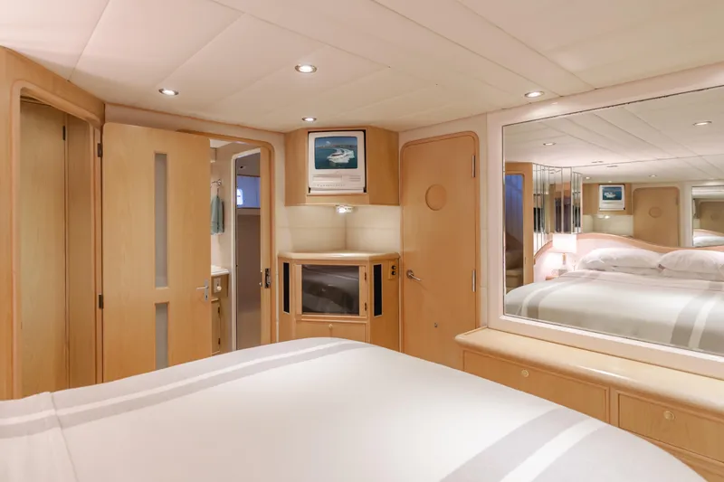 Artemis Yacht Photos Pics Luxurious 1996 Offshore Yachts Pilothouse bedroom with elegant wood finishes and modern amenities.