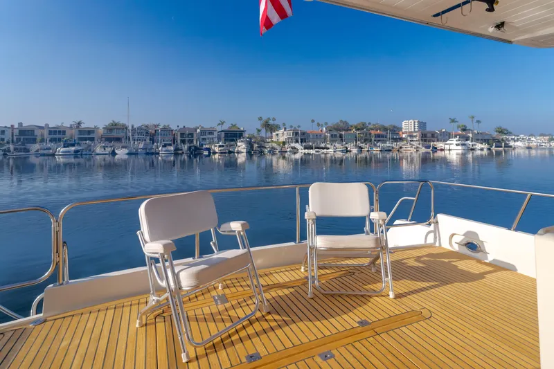 Artemis Yacht Photos Pics 1996 Offshore Yachts Pilothouse deck with chairs overlooking marina and calm waters.