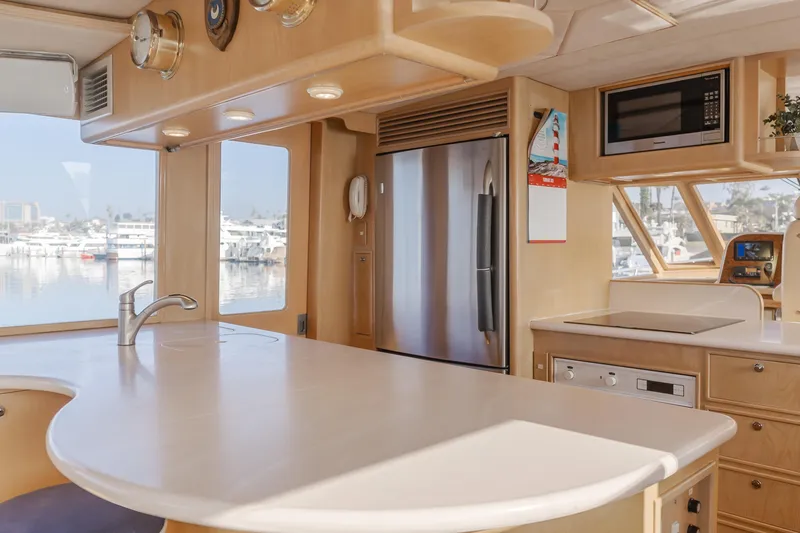 Artemis Yacht Photos Pics Interior of a 1996 Offshore Yachts Pilothouse kitchen with modern appliances and marina view.
