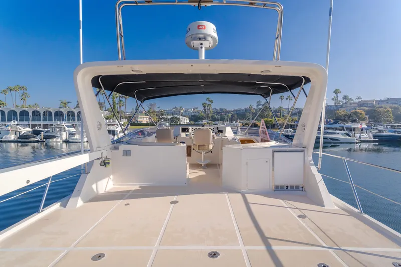 Artemis Yacht Photos Pics 1996 Offshore Yachts Pilothouse, spacious deck view, marina backdrop, clear blue sky.