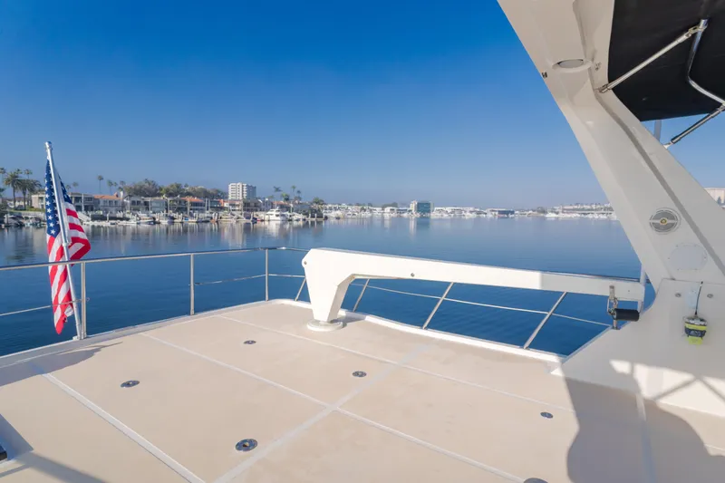 Artemis Yacht Photos Pics 1996 Offshore Yachts Pilothouse deck with marina view and American flag.