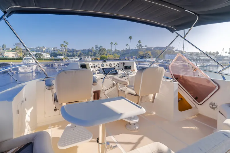 Artemis Yacht Photos Pics 1996 Offshore Yachts Pilothouse interior with steering wheel and seating, overlooking marina.
