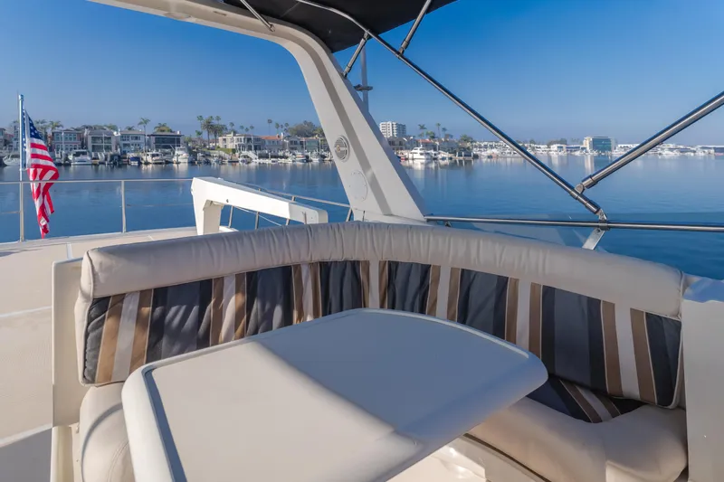 Artemis Yacht Photos Pics 1996 Offshore Yachts Pilothouse with seating area, overlooking a serene marina view.