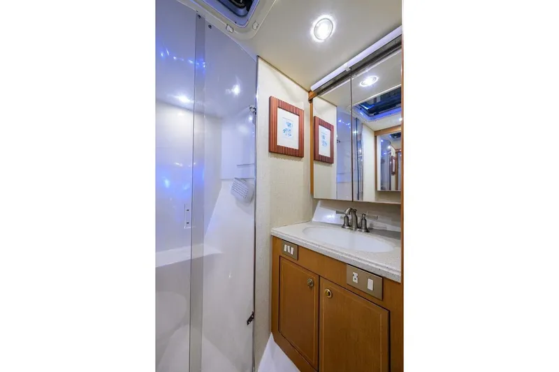 Hook'em Dan O Yacht Photos Pics Luxurious bathroom in 2006 Ocean Yachts 57 Super Sport with modern fixtures and wood cabinetry.