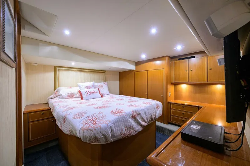 Hook'em Dan O Yacht Photos Pics Luxurious bedroom interior of 2006 Ocean Yachts 57 Super Sport with cozy bedding and wooden cabinetry.
