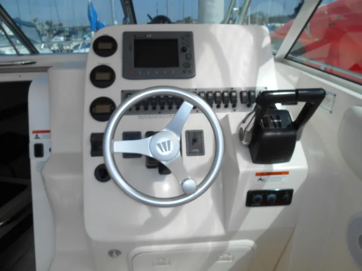 Delfini Yacht Photos Pics 2007 Wellcraft Coastal 270 boat helm with steering wheel and control panel.