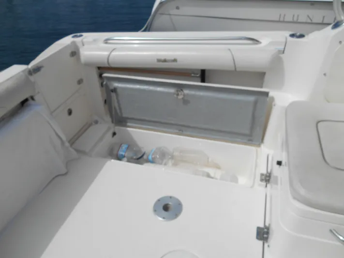 Delfini Yacht Photos Pics 2007 Wellcraft Coastal 270 boat interior with storage compartment and empty bottles.