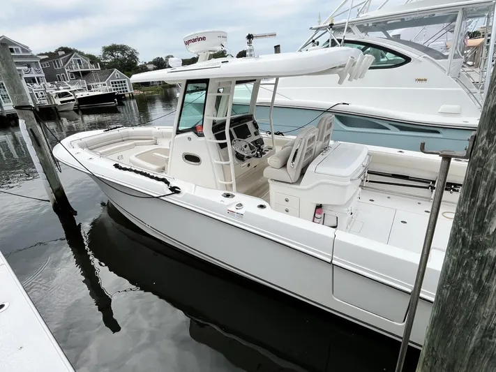  Yacht Photos Pics 2018 Boston Whaler 330 Outrage boat docked at marina, featuring sleek design and modern equipment.