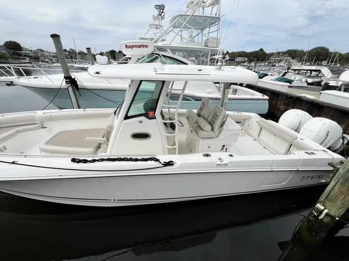  Yacht Photos Pics 2018 Boston Whaler 330 Outrage boat docked, featuring spacious seating and modern equipment.