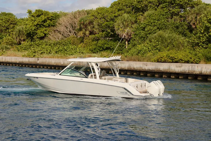  Yacht Photos Pics 2021 Boston Whaler 320 Vantage boat cruising on a scenic waterway.