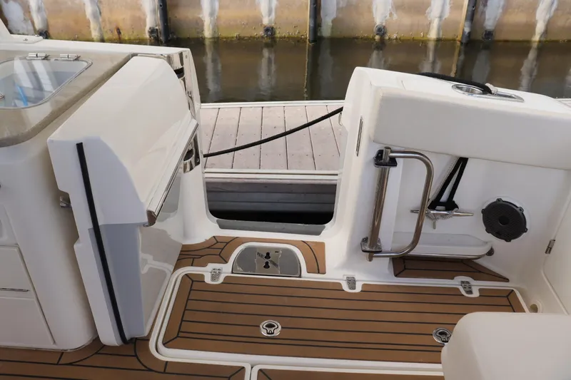  Yacht Photos Pics 2021 Boston Whaler 320 Vantage boat interior with teak flooring and dock view.
