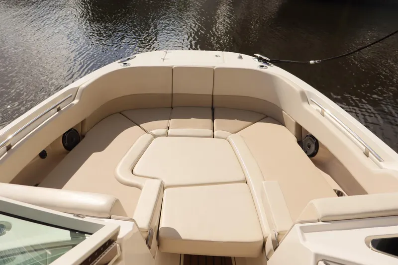  Yacht Photos Pics 2021 Boston Whaler 320 Vantage boat interior with beige seating, docked on calm water.