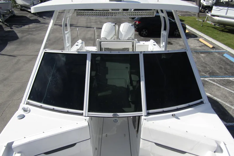  Yacht Photos Pics 2023 Blackfin 252 DC boat with sleek design and tinted windshield, docked outdoors.