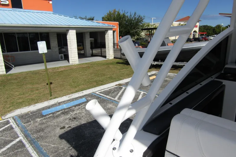  Yacht Photos Pics 2023 Blackfin 252 DC boat detail with rod holders in a parking lot.