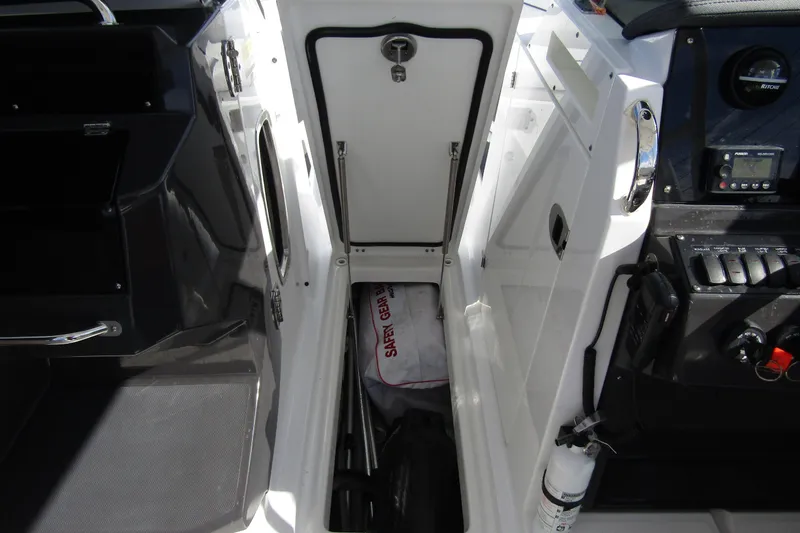  Yacht Photos Pics 2023 Blackfin 252 DC boat interior with open storage compartment and safety gear.