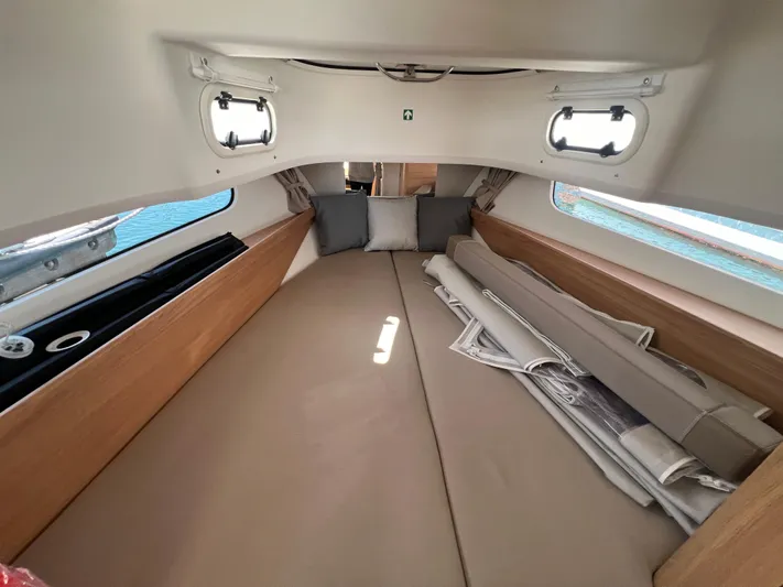 San #292 In Stock Yacht Photos Pics 2024 Nimbus T11 cabin interior with cozy bedding and cushions.