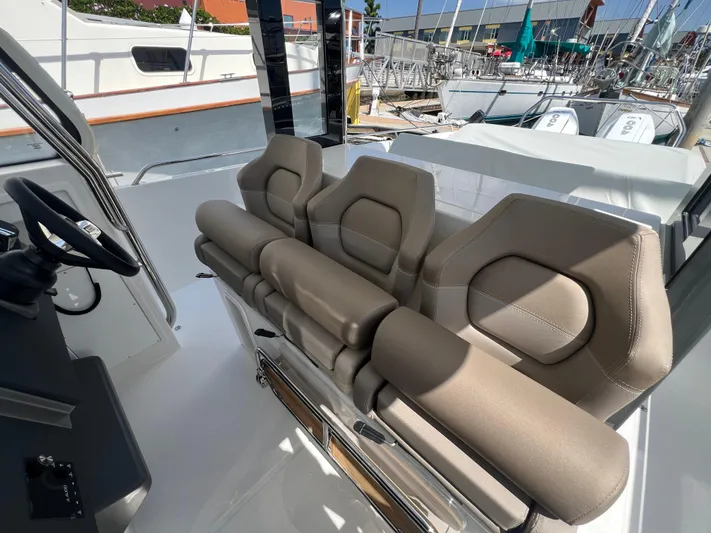 San #292 In Stock Yacht Photos Pics 2024 Nimbus T11 boat interior with beige seating and steering wheel.
