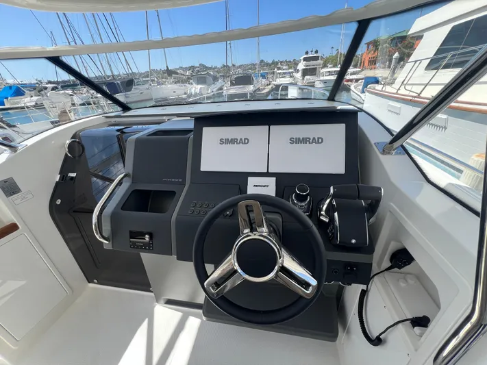San #292 In Stock Yacht Photos Pics Nimbus T11 2024 boat dashboard with Simrad navigation system, marina view.