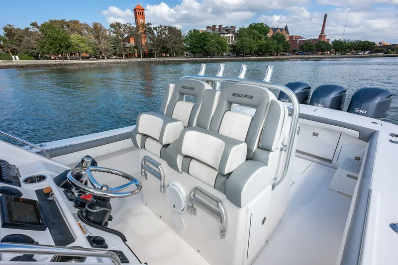 Dauntless Yacht Photos Pics 2018 Regulator 34 FS boat interior with helm and seating, docked by scenic waterfront.