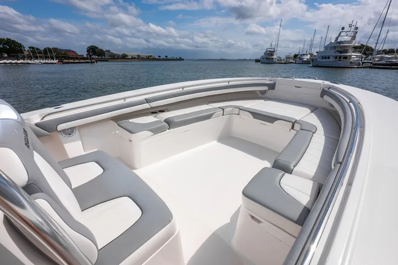 Dauntless Yacht Photos Pics 2018 Regulator 34 FS boat with spacious seating, docked in a marina under a cloudy sky.