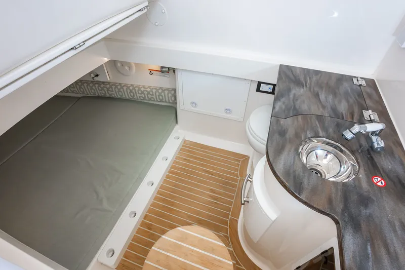 Dauntless Yacht Photos Pics 2018 Regulator 34 FS cabin interior with bed, sink, and wooden flooring.