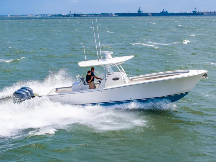 Dauntless Yacht Photos Pics 2018 Regulator 34 FS boat cruising on open water with two passengers.