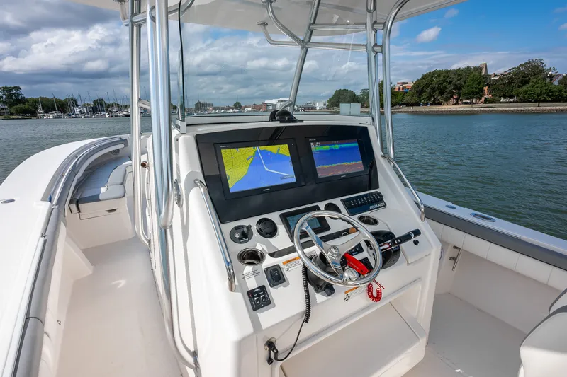 Dauntless Yacht Photos Pics 2018 Regulator 34 FS boat cockpit with navigation screens and steering wheel on calm water.