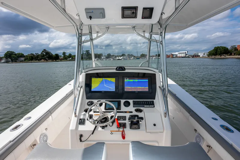 Dauntless Yacht Photos Pics 2018 Regulator 34 FS boat cockpit with navigation screens on a calm waterway.