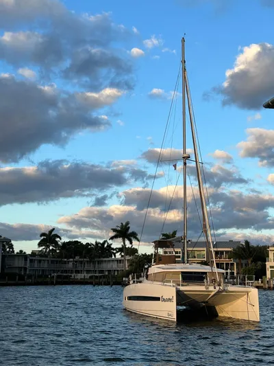 Encore Yacht Photos Pics Catamaran Bali 4.1 sailing on a calm waterway under a partly cloudy sky.