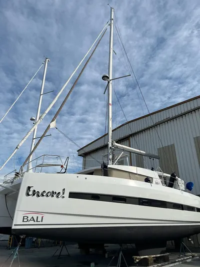 Encore Yacht Photos Pics Sailboat Bali 4.1, 2020 model, docked near a warehouse under a cloudy sky.