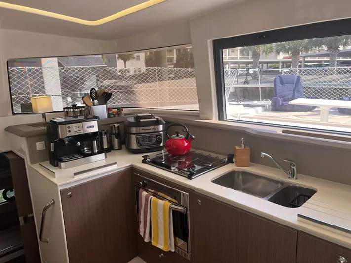 Encore Yacht Photos Pics Modern yacht kitchen with appliances, red kettle, and large window view. Bali 4.1, 2020 model.