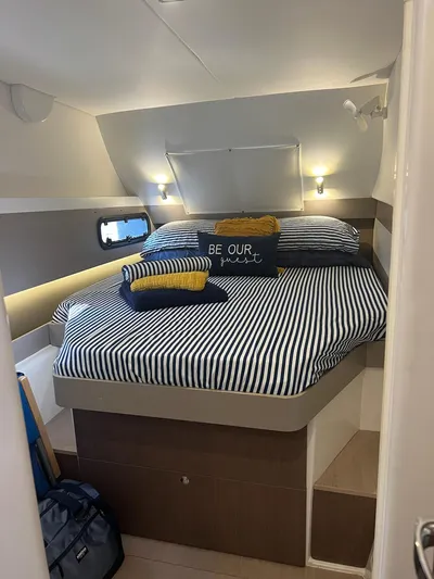 Encore Yacht Photos Pics Cozy cabin bedroom in 2020 Bali 4.1 yacht with striped bedding and decorative pillows.