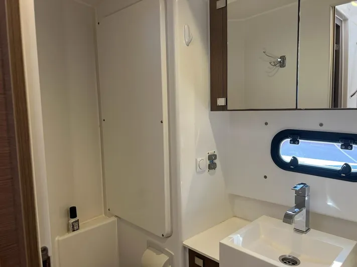 Encore Yacht Photos Pics Compact bathroom in a 2020 Bali 4.1 yacht with sink, mirror, and porthole window.