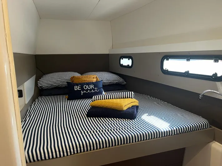 Encore Yacht Photos Pics Cozy cabin bedroom in 2020 Bali 4.1 yacht with striped bedding and decorative pillows.