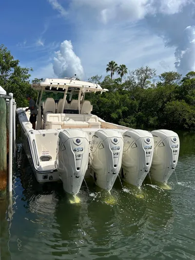 Yacht Photos Pics 2024 Grady-White Canyon 456 boat with four powerful outboard engines docked in water.