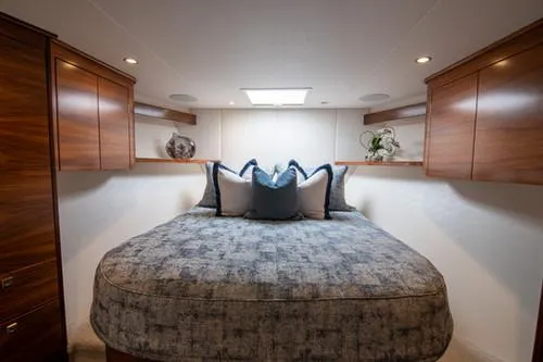 Caballo Grande Yacht Photos Pics Luxurious 2024 Viking Convertible EB yacht bedroom with elegant wood cabinetry and plush bedding.