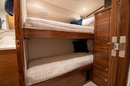 Caballo Grande Yacht Photos Pics 2024 Viking Convertible EB yacht interior with cozy bunk beds and wooden cabinetry.