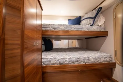 Caballo Grande Yacht Photos Pics 2024 Viking Convertible EB interior with wooden bunk beds and cozy bedding.